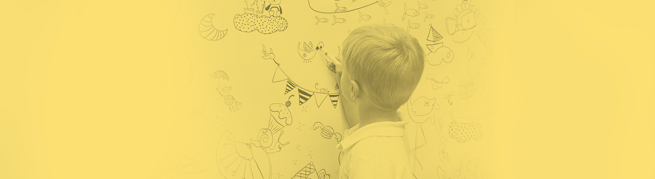 Photographie d'un enfant qui dessine au tableau.