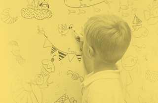 Photographie d'un enfant qui dessine au tableau.